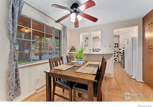 dining room featuring light wood finished floors, ceiling fan, and baseboards
