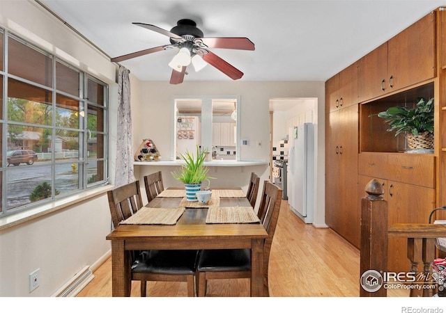 dining area featuring light wood finished floors, ceiling fan, and baseboards