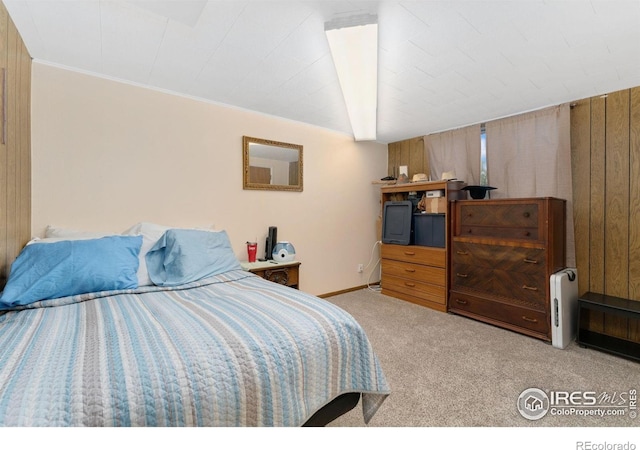 bedroom featuring carpet flooring and wooden walls