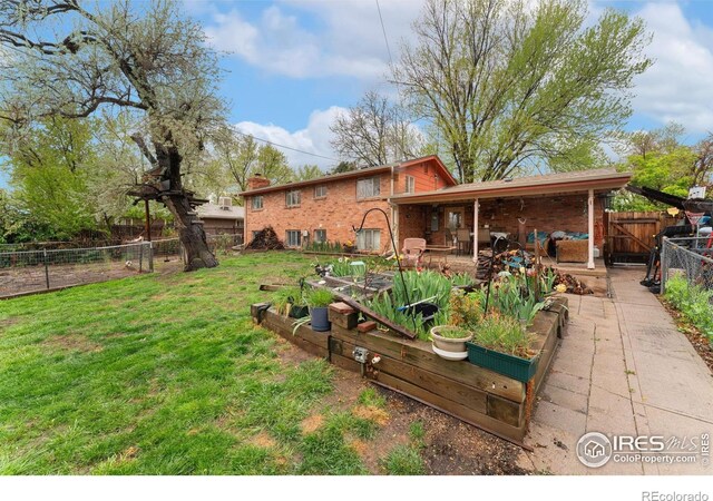 back of property with a vegetable garden, brick siding, and a chimney