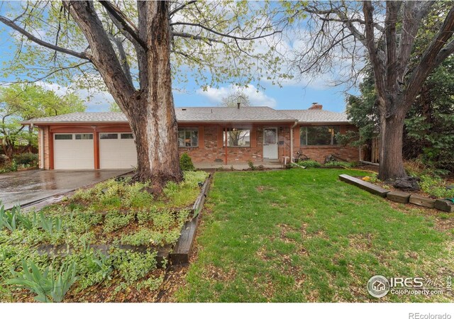 ranch-style home featuring an attached garage, concrete driveway, a chimney, a front lawn, and brick siding