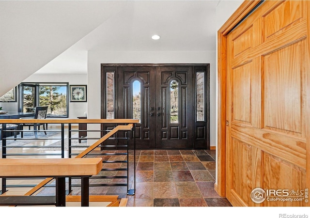 entryway featuring stone tile floors, recessed lighting, and baseboards