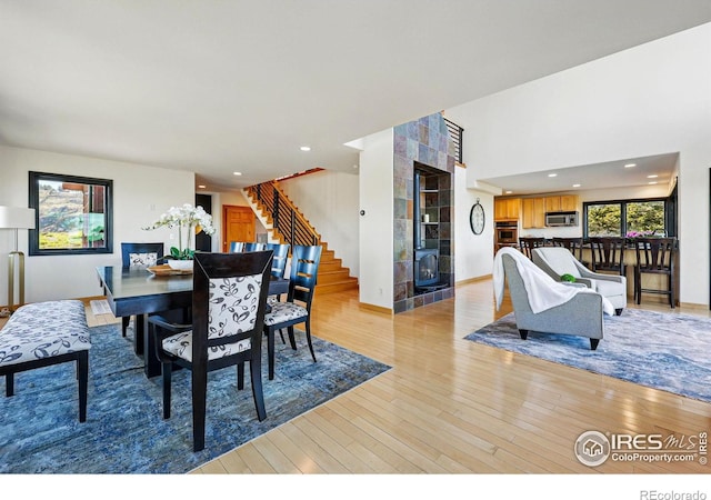 dining space with stairway, light wood-style flooring, recessed lighting, and baseboards
