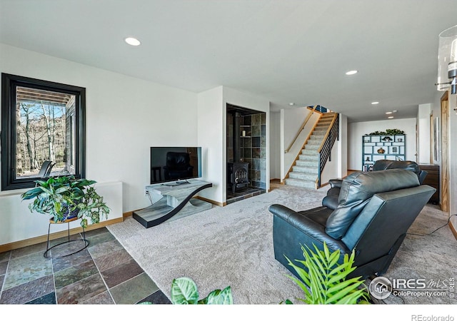 living room featuring stairway, baseboards, recessed lighting, and stone finish floors