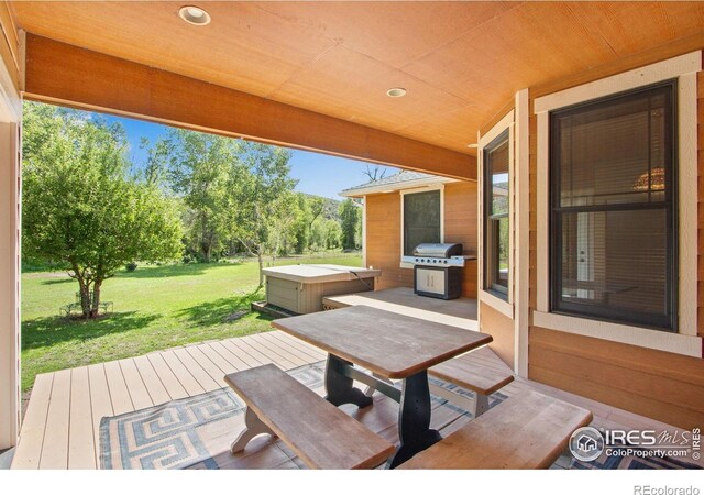 view of patio featuring a grill, a hot tub, a wooden deck, and outdoor dining space