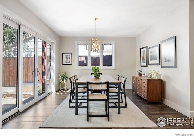 dining room with a chandelier, dark wood-style floors, and baseboards