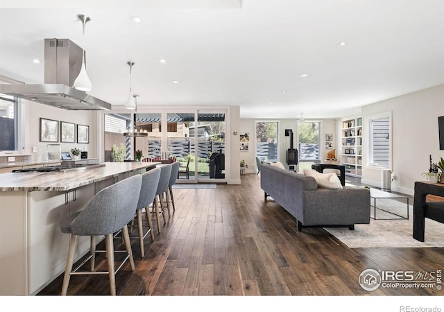 living area with dark wood-style floors, recessed lighting, and baseboards