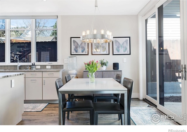 dining space featuring light wood-style flooring and a chandelier