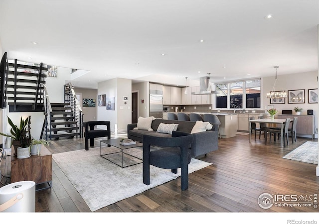 living area with stairs, dark wood finished floors, a chandelier, and recessed lighting