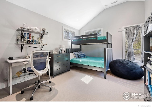 carpeted bedroom with lofted ceiling and a desk