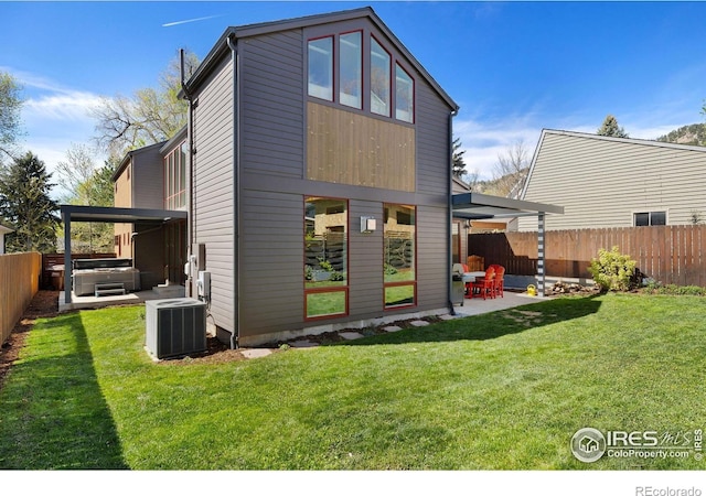 rear view of house featuring a hot tub, central air condition unit, and a patio area