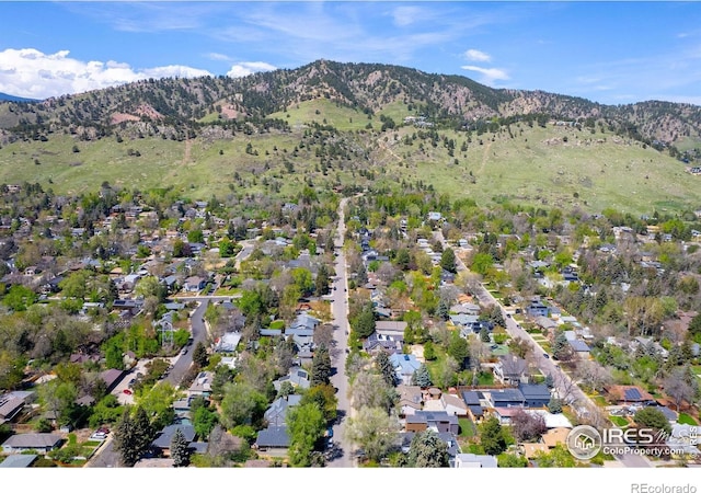 aerial view of property's location with a mountainous background and nearby suburban area