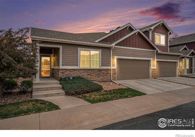 craftsman-style home featuring board and batten siding, stone siding, concrete driveway, and an attached garage