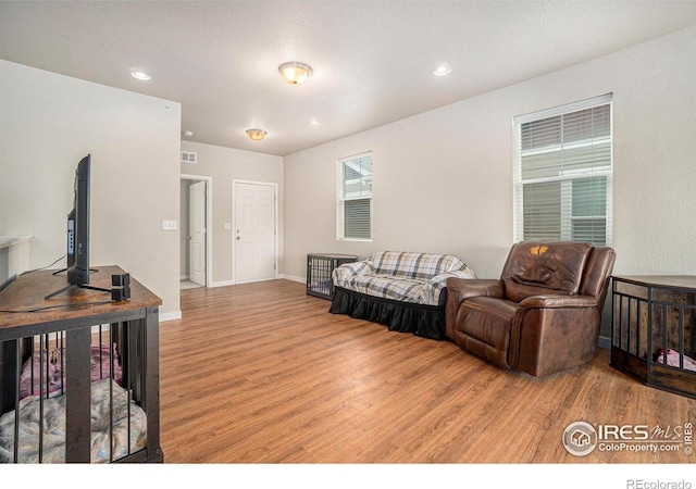 living area featuring light wood-style flooring, recessed lighting, and baseboards