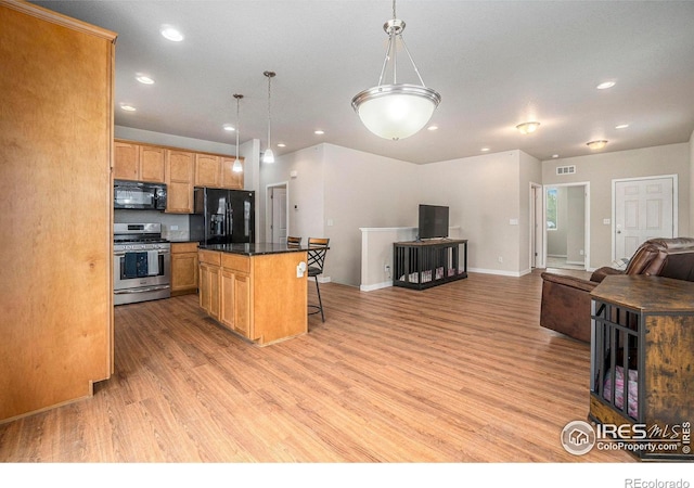 kitchen with black appliances, open floor plan, light wood finished floors, recessed lighting, and a kitchen island