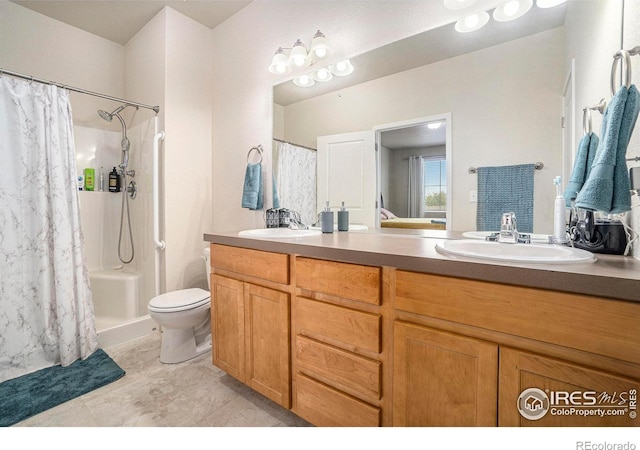 bathroom featuring double vanity, a shower with shower curtain, and toilet