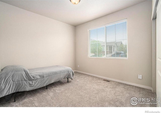 bedroom with carpet flooring and baseboards
