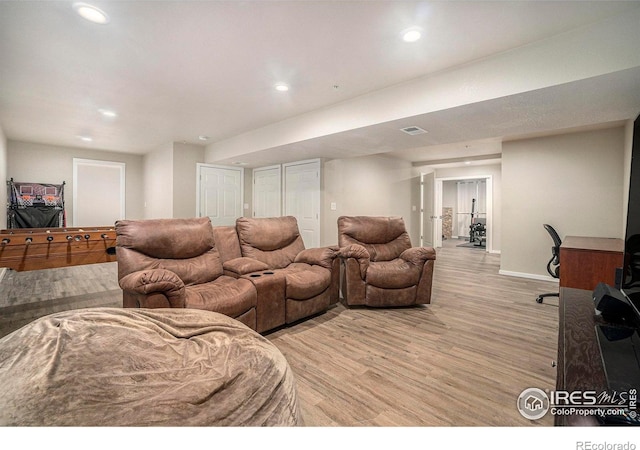 living room featuring light wood finished floors, recessed lighting, and baseboards