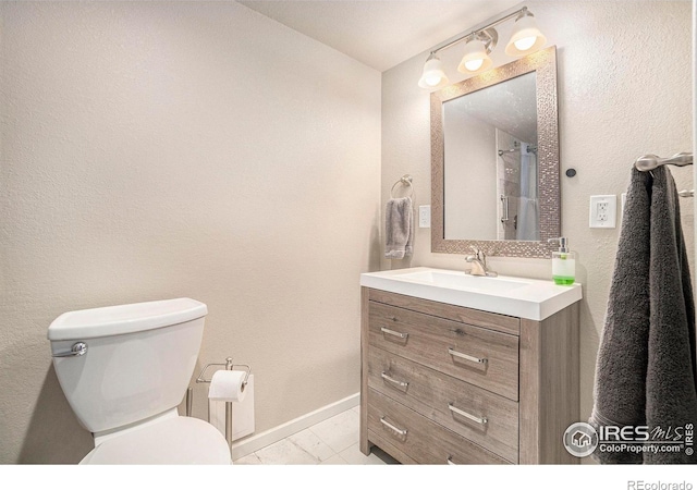 bathroom with vanity, toilet, and baseboards