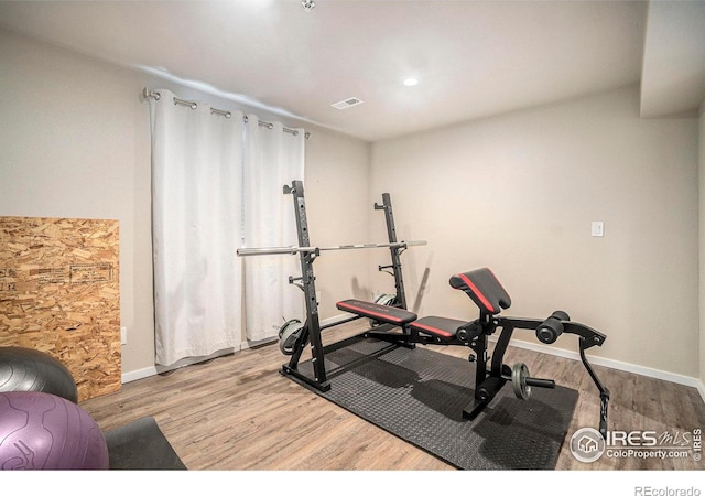 workout room featuring wood finished floors and baseboards