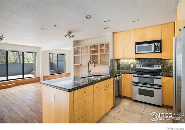 836 Walnut St Unit B, Boulder, CO 80302 - kitchen with stainless steel appliances, a sink, a peninsula, light brown cabinetry, and tasteful backsplash