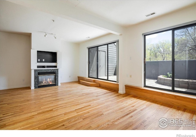836 Walnut St Unit B, Boulder, CO 80302 - unfurnished living room with light wood-style flooring, a glass covered fireplace, and baseboards