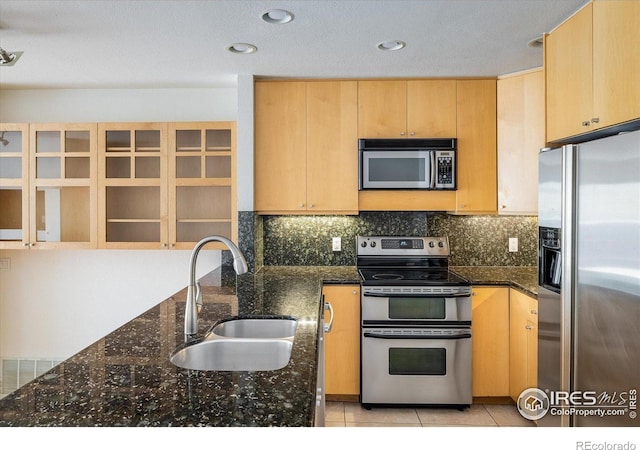 836 Walnut St Unit B, Boulder, CO 80302 - kitchen featuring appliances with stainless steel finishes, a sink, light brown cabinetry, dark stone countertops, and light tile patterned floors