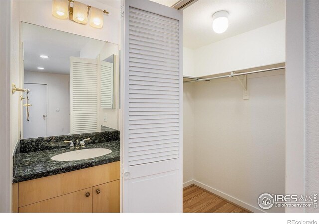 836 Walnut St Unit B, Boulder, CO 80302 - bathroom featuring wood finished floors, vanity, baseboards, and a walk in closet
