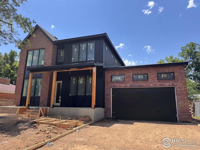 2941 21st St, Boulder, CO 80304 - view of front of home featuring board and batten siding, brick siding, dirt driveway, and a garage