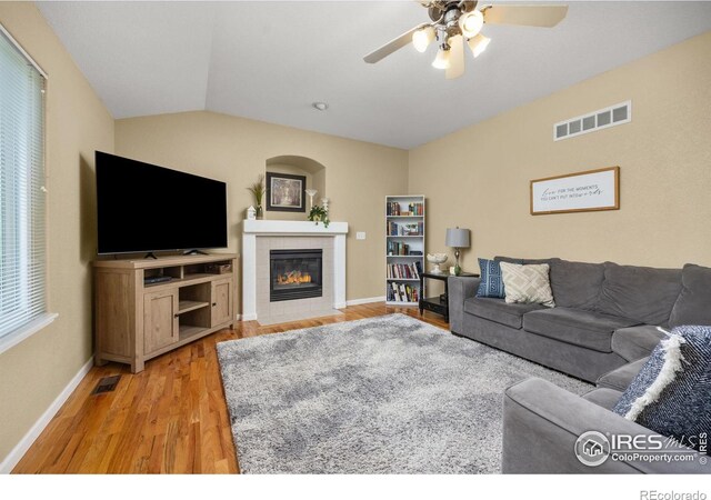 316 Whitney Bay, Windsor, CO 80550 - living area featuring light wood-type flooring, ceiling fan, a tile fireplace, baseboards, and vaulted ceiling