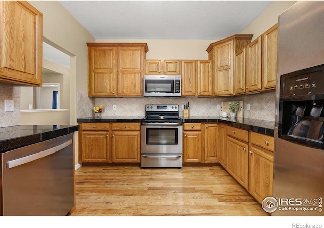 316 Whitney Bay, Windsor, CO 80550 - kitchen with appliances with stainless steel finishes, light wood-style flooring, decorative backsplash, brown cabinetry, and tile countertops