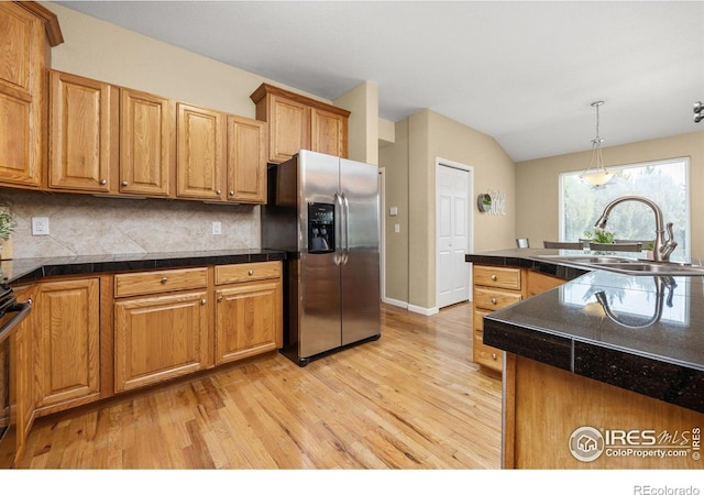 316 Whitney Bay, Windsor, CO 80550 - kitchen featuring stainless steel fridge, a sink, light wood finished floors, backsplash, and vaulted ceiling