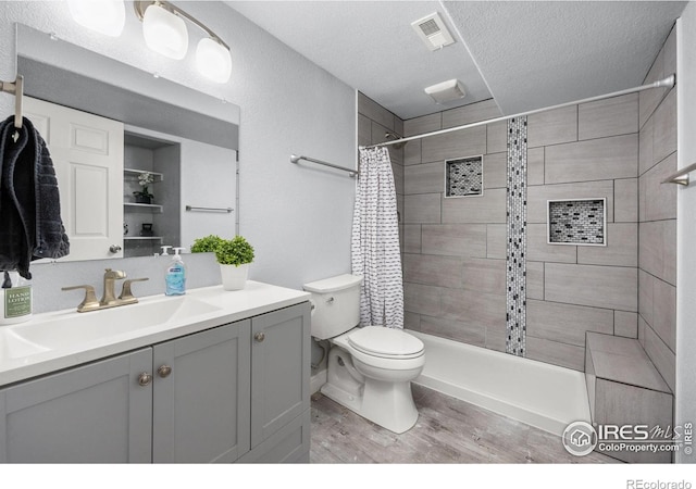 316 Whitney Bay, Windsor, CO 80550 - bathroom with a textured ceiling, wood finished floors, a tile shower, toilet, and vanity