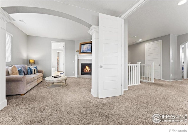 6111 Story Rd, Timnath, CO 80547 - living room featuring carpet floors, arched walkways, baseboards, a glass covered fireplace, and recessed lighting