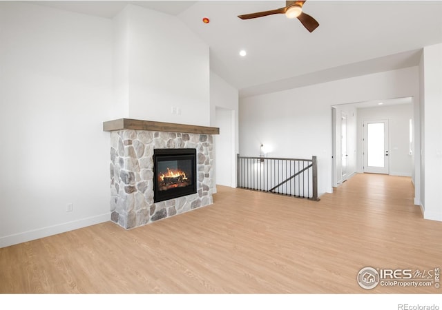 20 Snowcap Dr, Windsor, CO 80550 - unfurnished living room featuring a ceiling fan, wood finished floors, baseboards, a fireplace, and high vaulted ceiling