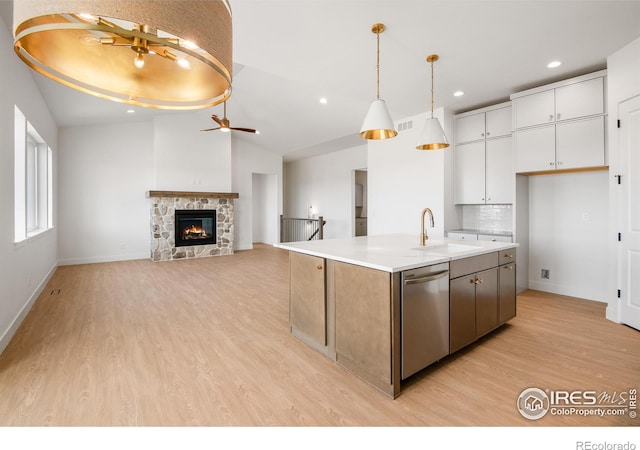 20 Snowcap Dr, Windsor, CO 80550 - kitchen with dishwasher, a sink, light wood finished floors, baseboards, and white cabinetry