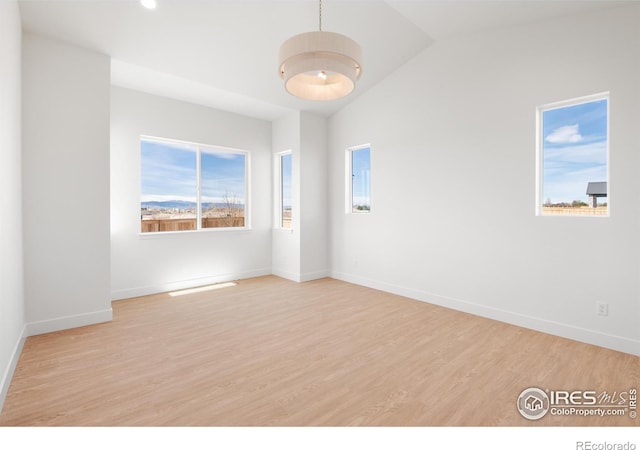 20 Snowcap Dr, Windsor, CO 80550 - empty room with wood finished floors, lofted ceiling, and baseboards