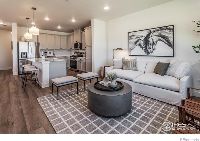 living room with dark wood-type flooring, recessed lighting, and baseboards