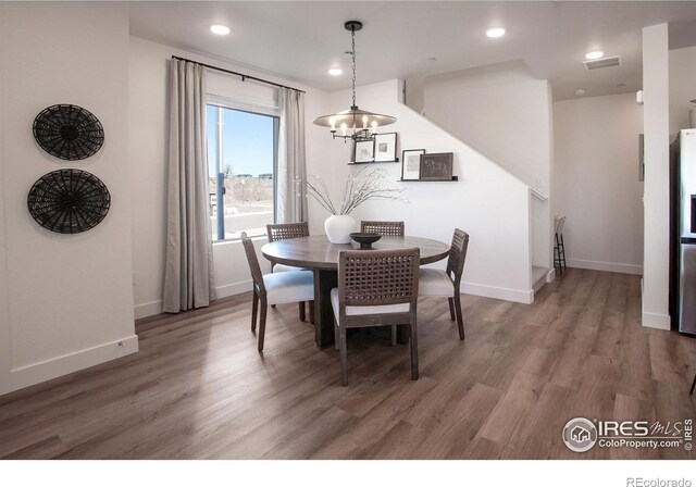 dining space featuring a chandelier, light wood-type flooring, baseboards, and recessed lighting