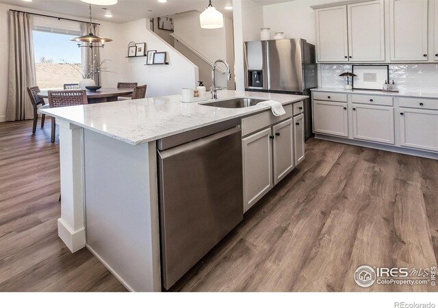kitchen featuring stainless steel appliances, a sink, dark wood-style floors, tasteful backsplash, and recessed lighting