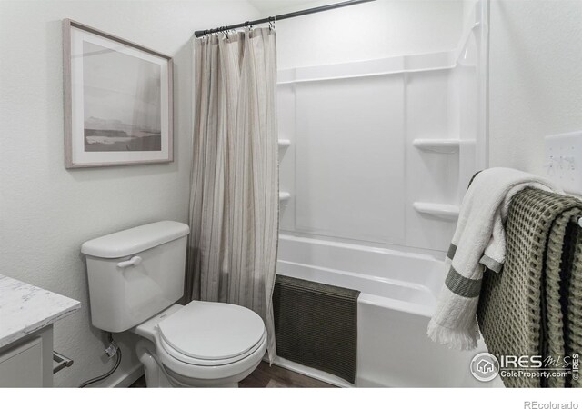bathroom with vanity, shower / bathtub combination with curtain, and toilet