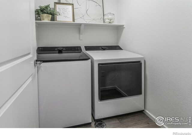 washroom featuring washing machine and clothes dryer and wood finished floors