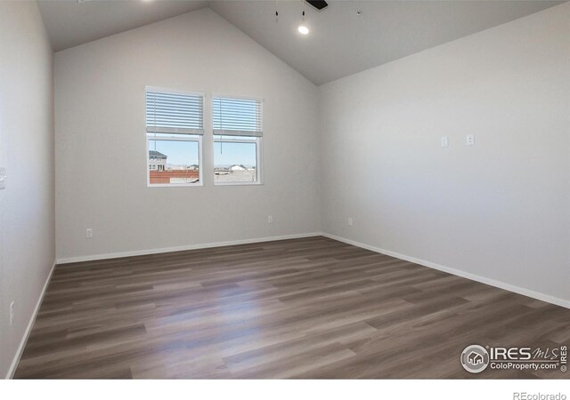 spare room featuring ceiling fan, wood finished floors, vaulted ceiling, and baseboards