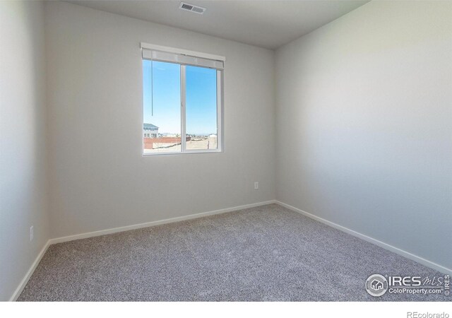 unfurnished room featuring carpet and baseboards