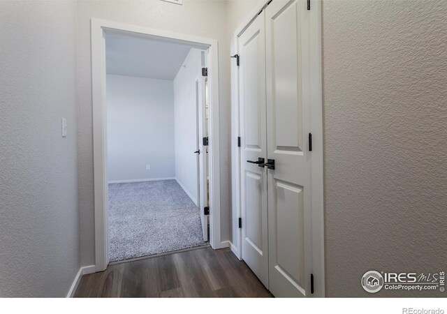 hallway with dark wood-style floors and baseboards