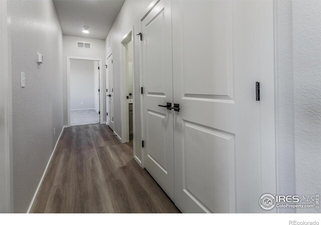 hall featuring dark wood-style floors and baseboards