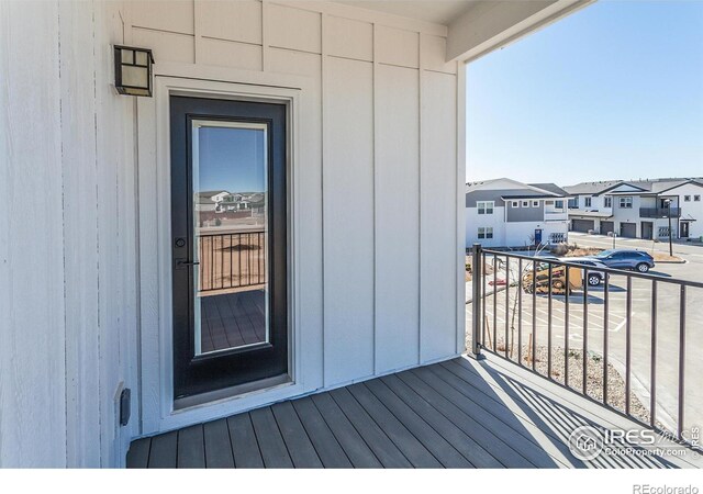 entrance to property featuring a balcony and a residential view