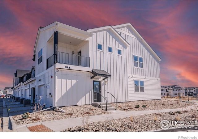 1821 Bounty Dr Unit 1, Windsor, CO 80550 - view of front facade with board and batten siding, a balcony, a garage, and central AC