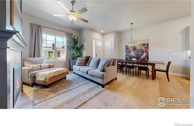 4157 Trapper Lake Dr, Loveland, CO 80538 - living area featuring a chandelier, a ceiling fan, a glass covered fireplace, light wood-style flooring, and recessed lighting