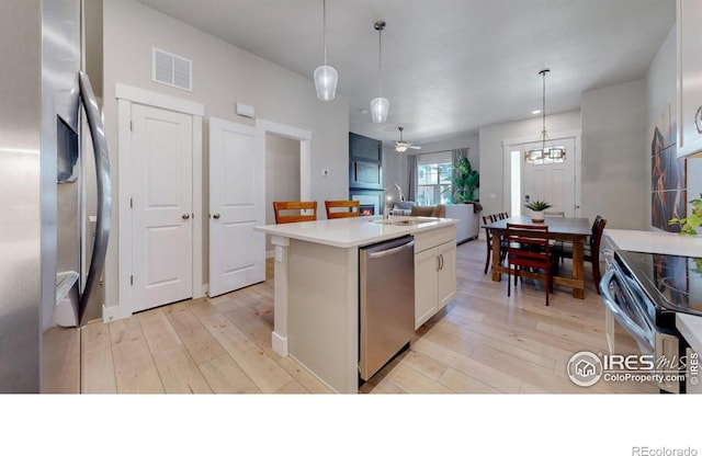 4157 Trapper Lake Dr, Loveland, CO 80538 - kitchen featuring dishwasher, light wood finished floors, a sink, and a center island with sink